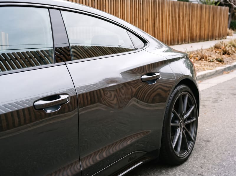 Paintless dent repair in Los Angeles: the rear door of a gray Audi RS e-tron GT with a large dent bending the reflection