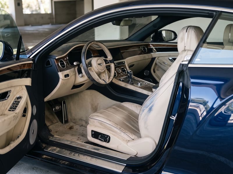 Car detailing for leather seats in Los Angeles: the cream leather driver's seat of a Bentley Continental GT with blue denim dye transfer and grime in the grain